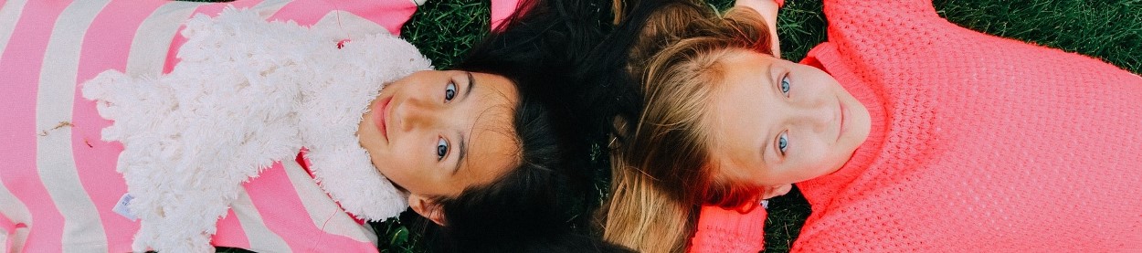 Photo of two girls lying down on a lawn